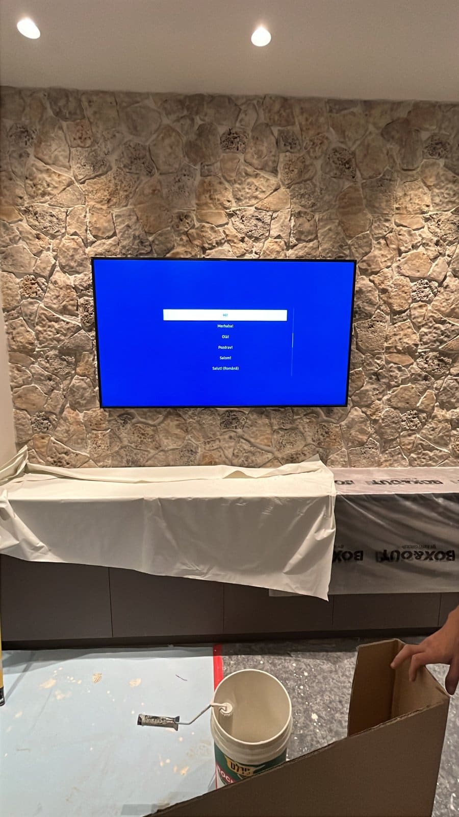 ארון מכוסה ניילון הגנה מתחת לטלוויזיה בזמן עבודה