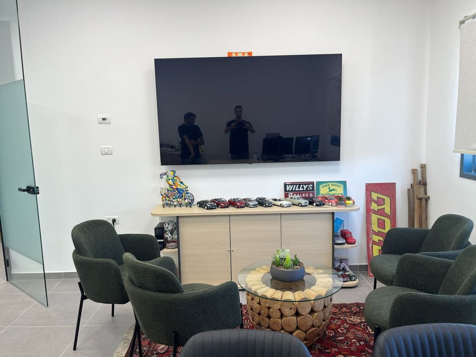 פינת ישיבה במשרד עם טלוויזיה תלויה